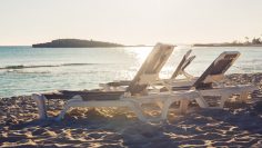 Sunbeds on the sea beach during sunset.