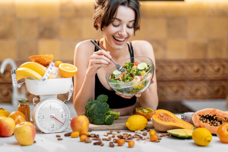 Sports woman with healthy food on the kitchen